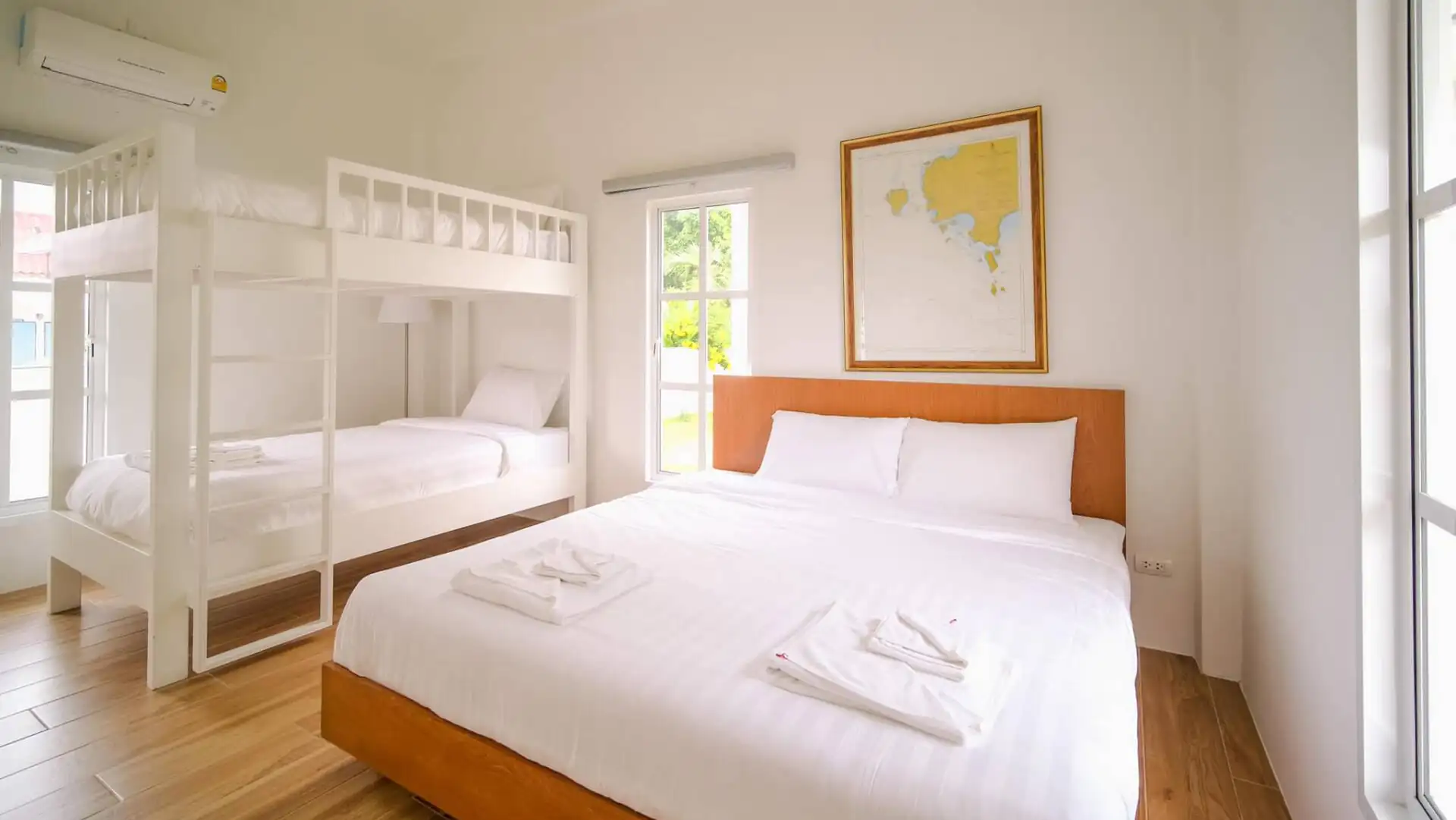 Phòng ngủ lớn trang trí theo phong cách tối giản, gồm một chiếc giường đôi và một chiếc giường tầng