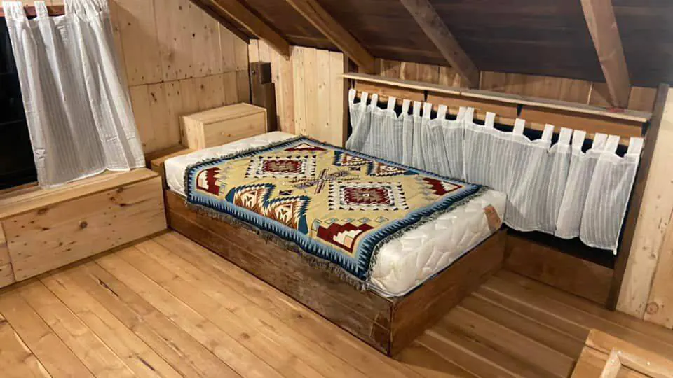 Giường ngủ gỗ có ga hoa văn ấn tượng, giúp cho không gian nghỉ ngơi không còn nhàm chán, đơn điệu