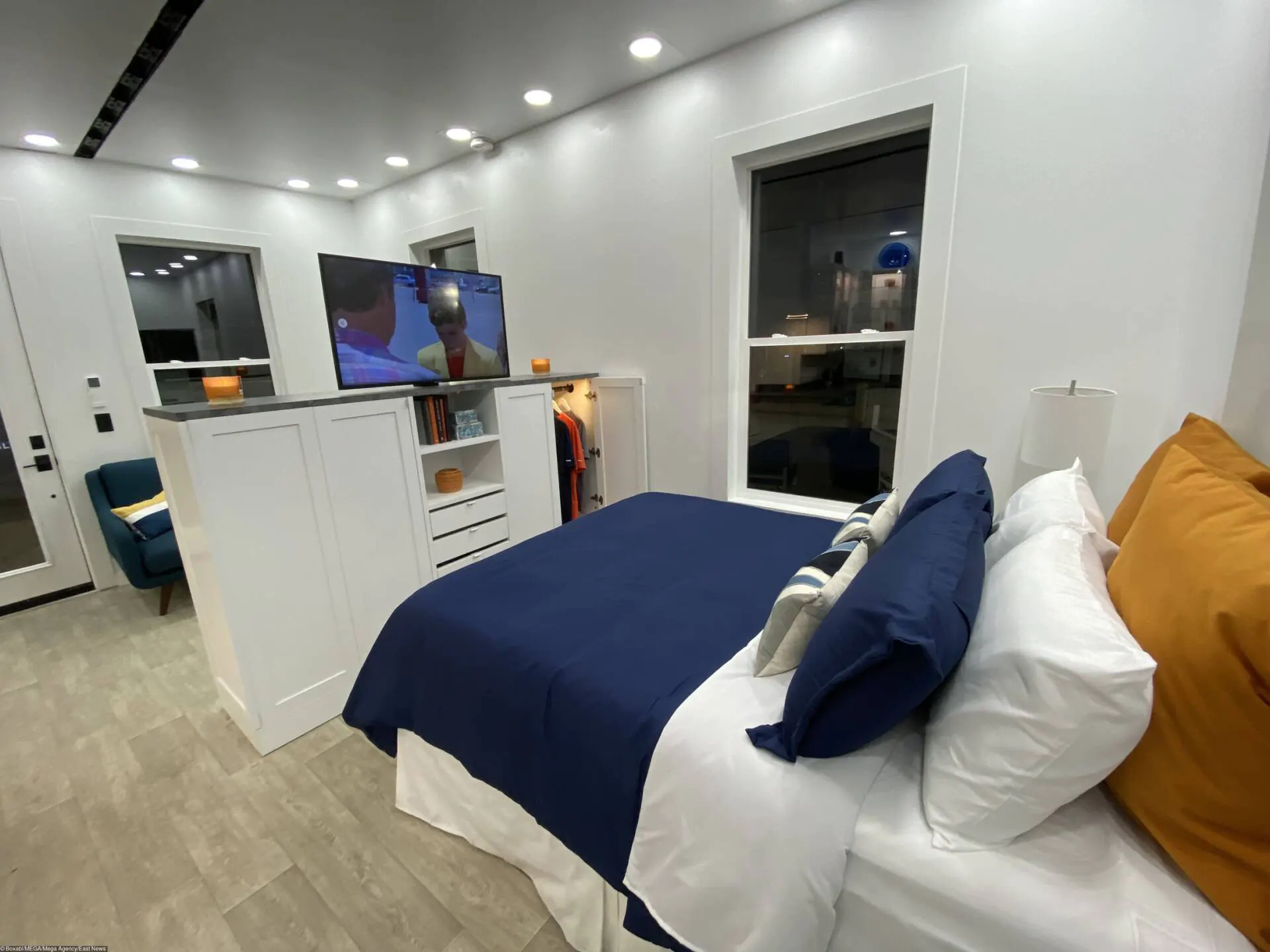 Phòng ngủ ngăn cách với phòng khách bằng kệ tủ thông minh, vừa là nơi để quần áo, vừa là kệ tivi có thể linh hoạt xoay giữa 2 không gian khách - ngủ 